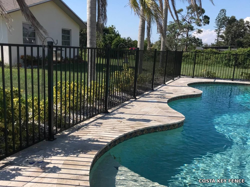 Black aluminum pool safety fence and gate installed around a residential pool near Sarasota, Florida