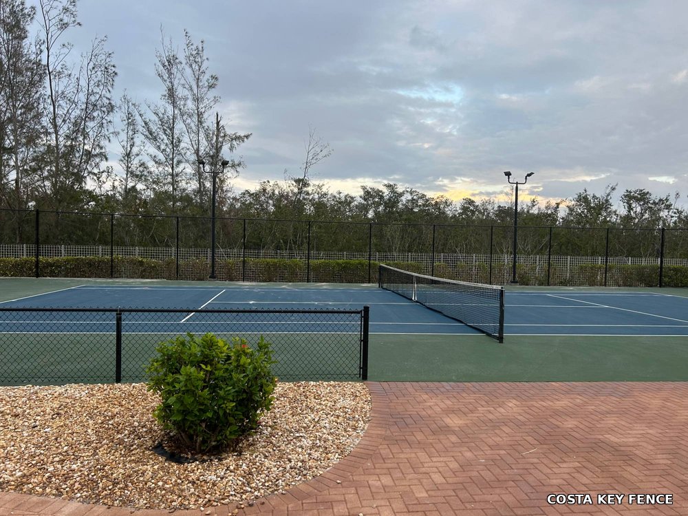 Black chain-link fence installed by Costa Key Fence around a tennis court near Sarasota, Florida